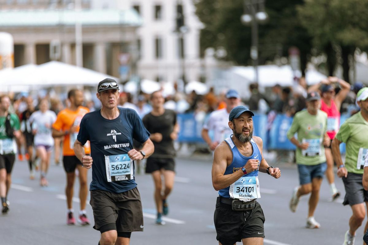 Focused runners competing in a vibrant city marathon event.